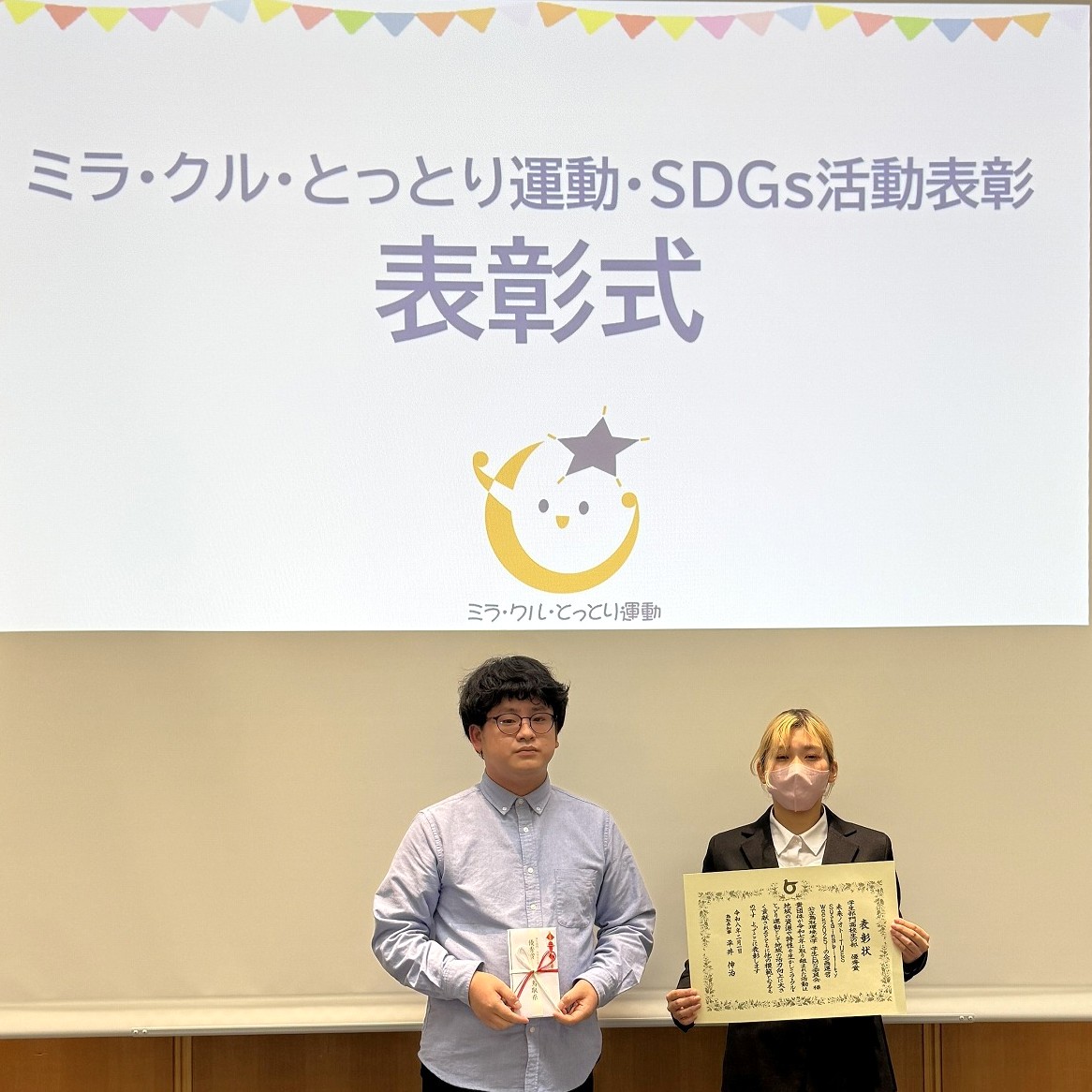 表彰状及び副賞を披露する受賞者